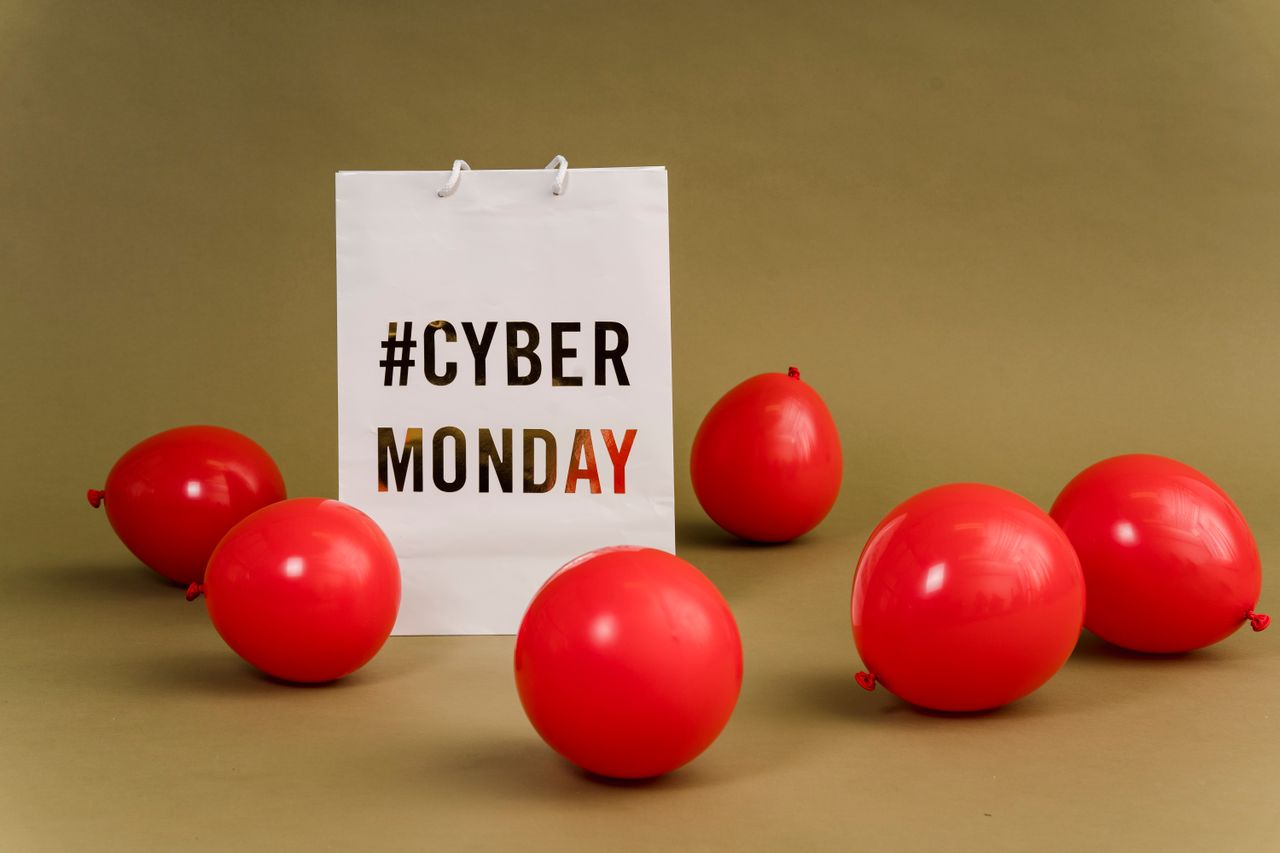 services-03 Shopping bag with hashtag Cyber Monday surrounded by vibrant red balloons.