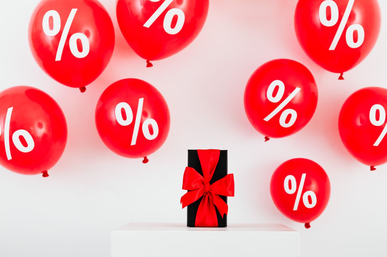 services-04 Red balloons with percent symbols and a gift box create a festive sale theme.
